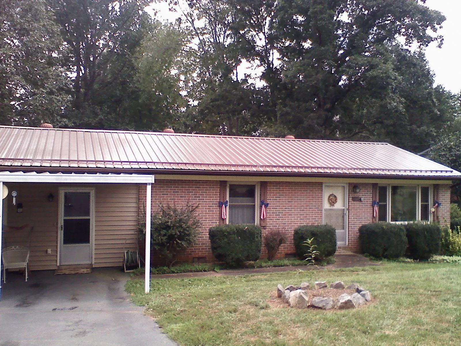 Bronze metal roof and carport on a brick ranch home — Roof Repair work by our crew in Vanderbilt